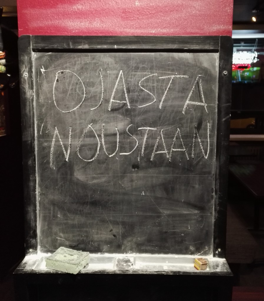 Liitutaulu, jossa lukee Ojasta noustaan!